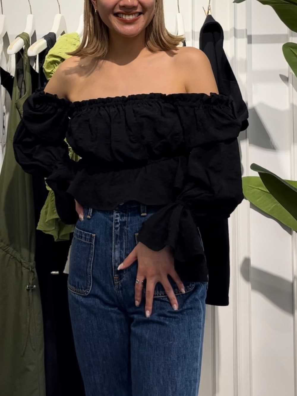 ブラック系のスニーカー、ブルー系のデニムパンツ、ブラック系のシャツ/ブラウスを着用したレディースの春コーディネートの2枚目の写真