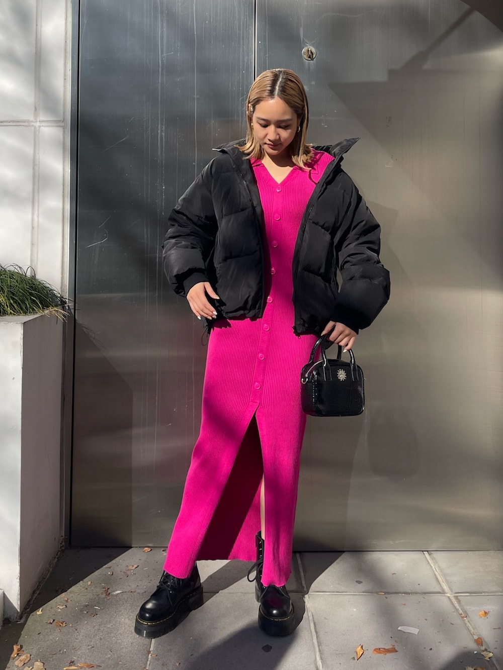 ブラック系のワンピース、ブラック系のショルダーバッグ、ブラック系のダウンジャケット/コートを着用したレディースの冬コーディネートの2枚目の写真