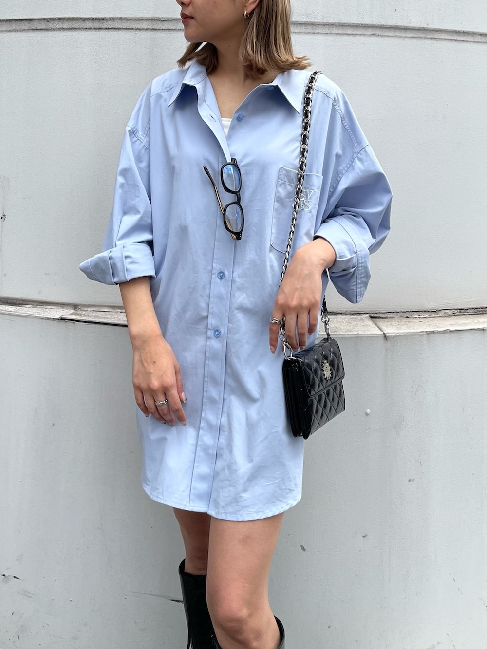 ブラック系のブーツ、ブラック系のショルダーバッグ、ブルー系のシャツ/ブラウスを着用したレディースの春コーディネートの6枚目の写真