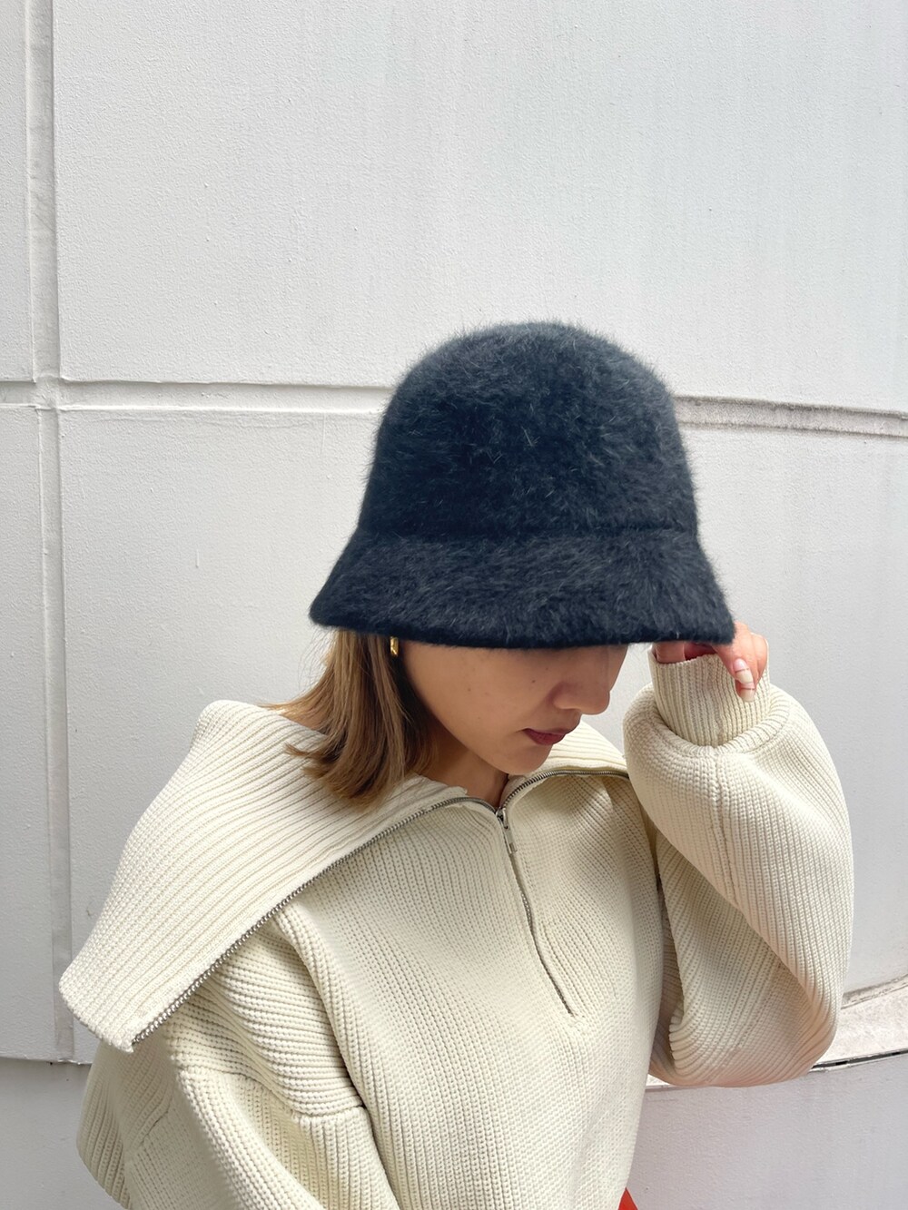 オレンジ系のスラックス、ホワイト系のニット/セーター、ブラック系のローファーを着用したレディースの秋コーディネートの7枚目の写真