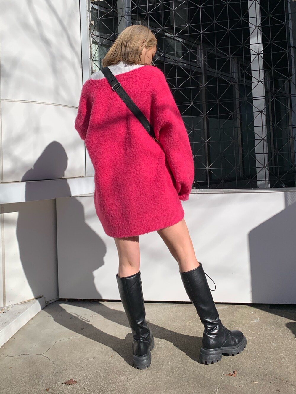 ピンク系のカーディガン/ボレロ、ホワイト系のTシャツ/カットソー、ブラック系のブーツを着用したレディースの冬コーディネートの3枚目の写真