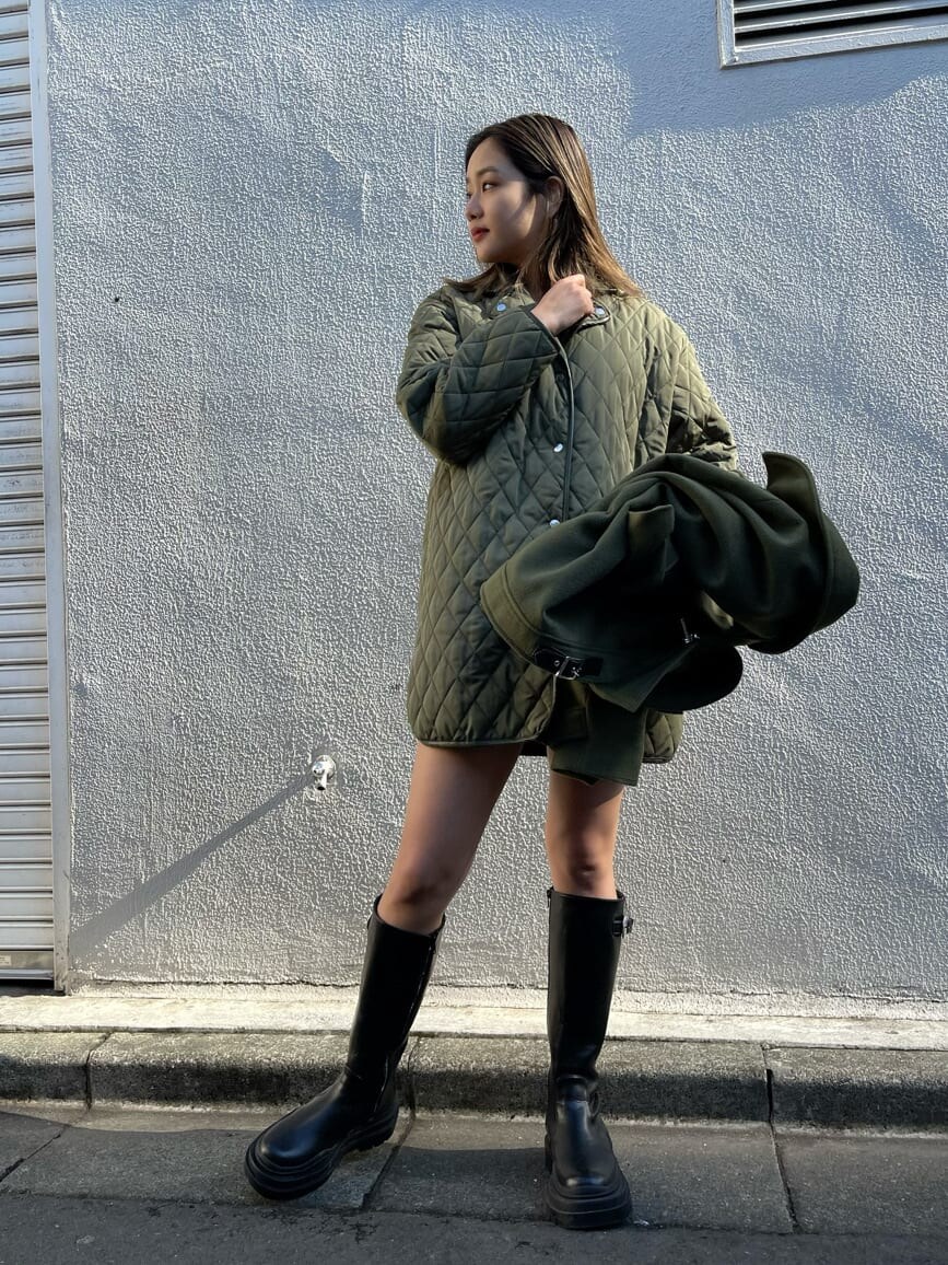 ベージュ系のブルゾン、ブラック系のニット/セーター、ブラック系のブーツを着用したレディースの冬コーディネートの3枚目の写真