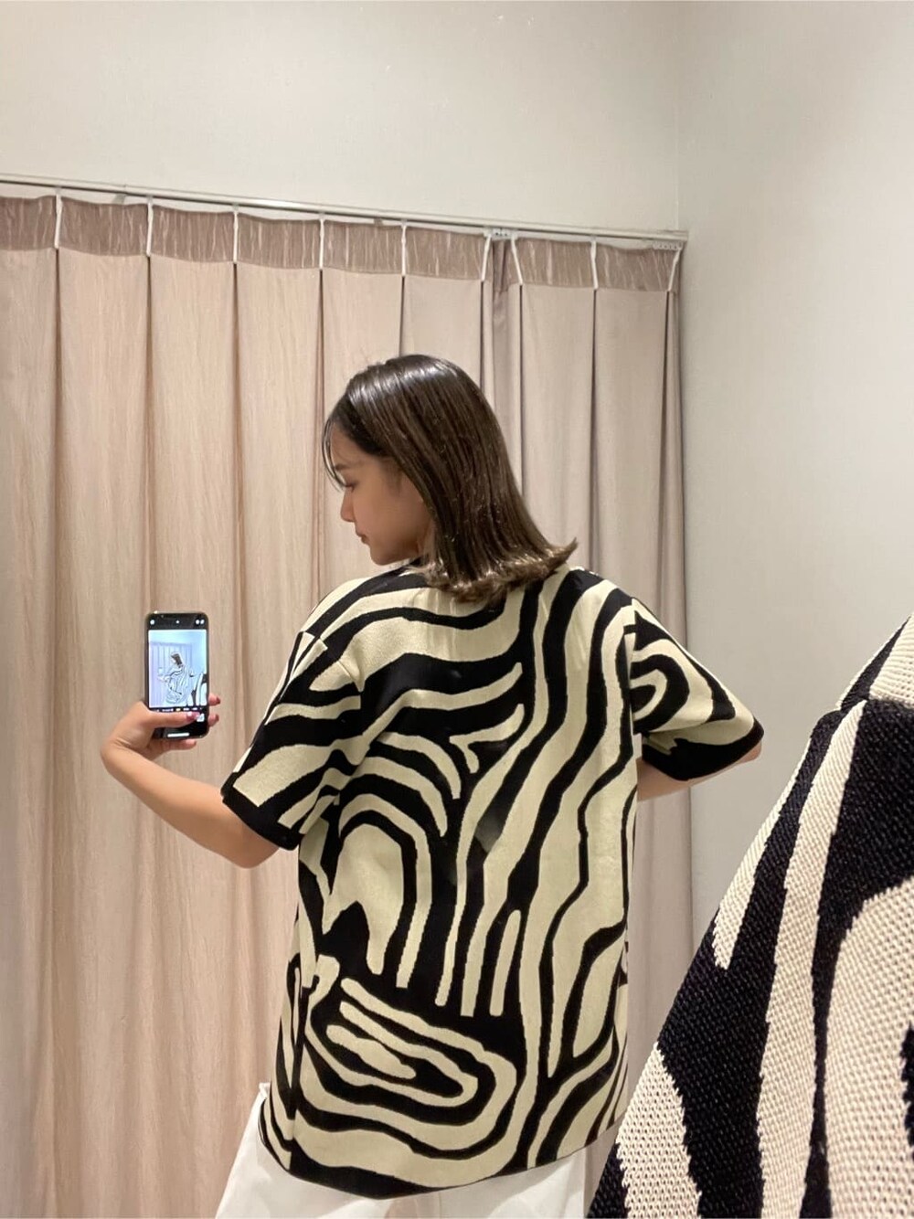 ホワイト系のキャミソール、ホワイト系のデニムパンツ、ブラック系のニット/セーターを着用したレディースの春コーディネートの8枚目の写真