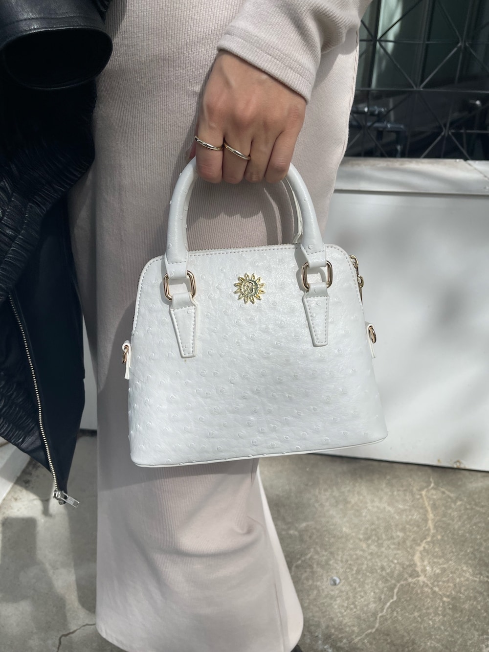 ホワイト系のワンピース、ホワイト系のショルダーバッグ、ブラック系のブルゾンを着用したレディースの秋コーディネートの6枚目の写真