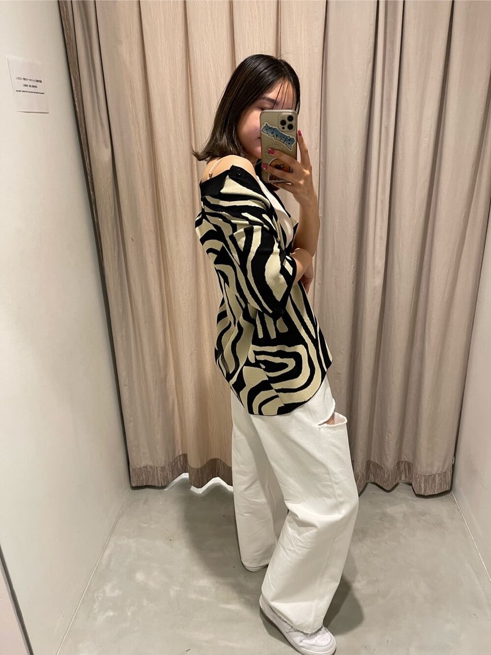 ホワイト系のキャミソール、ホワイト系のデニムパンツ、ブラック系のニット/セーターを着用したレディースの春コーディネートの4枚目の写真