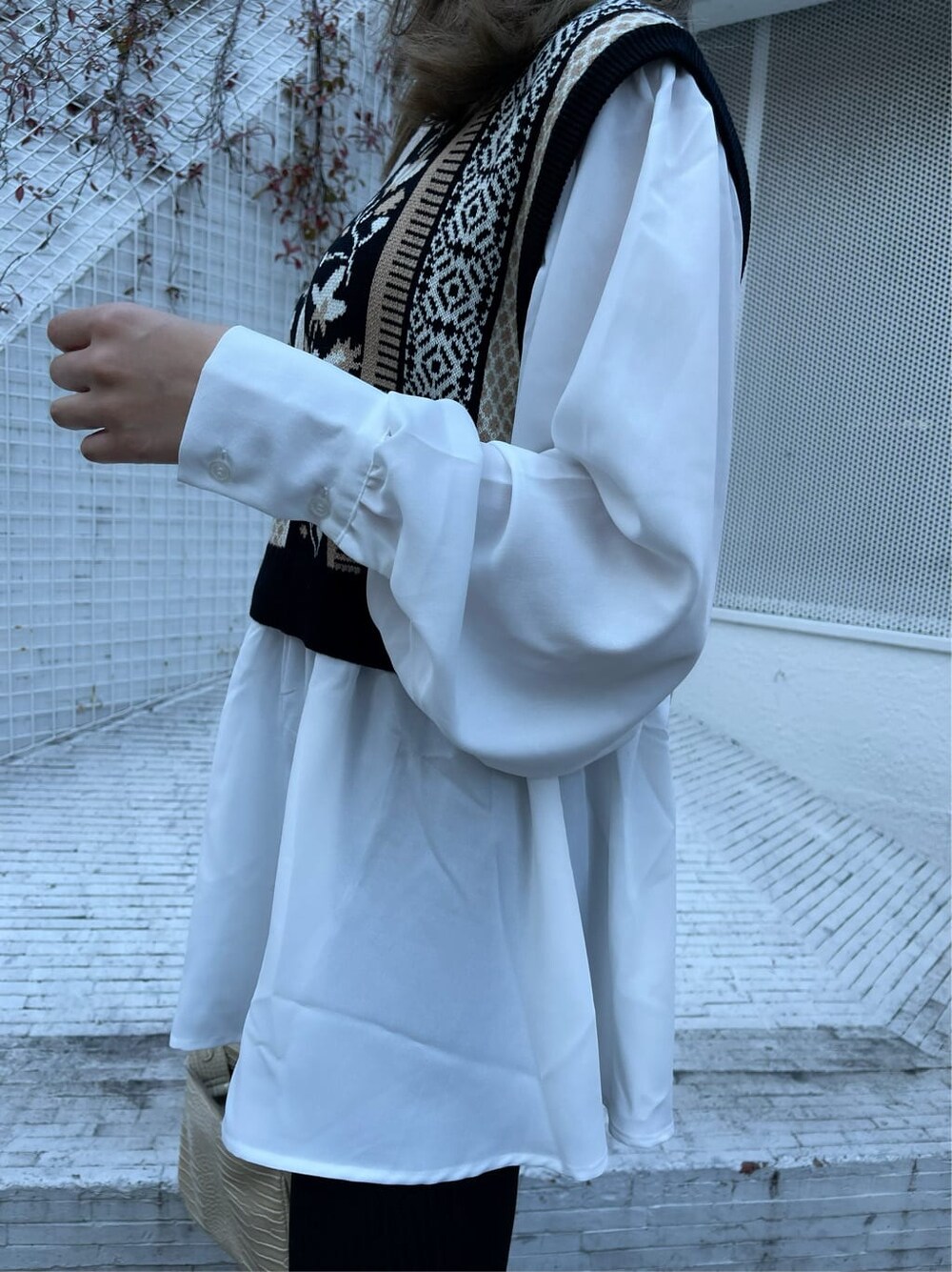 ブラック系のシャツ/ブラウス、ホワイト系のショルダーバッグ、ブラック系のブーツを着用したレディースの冬コーディネートの5枚目の写真