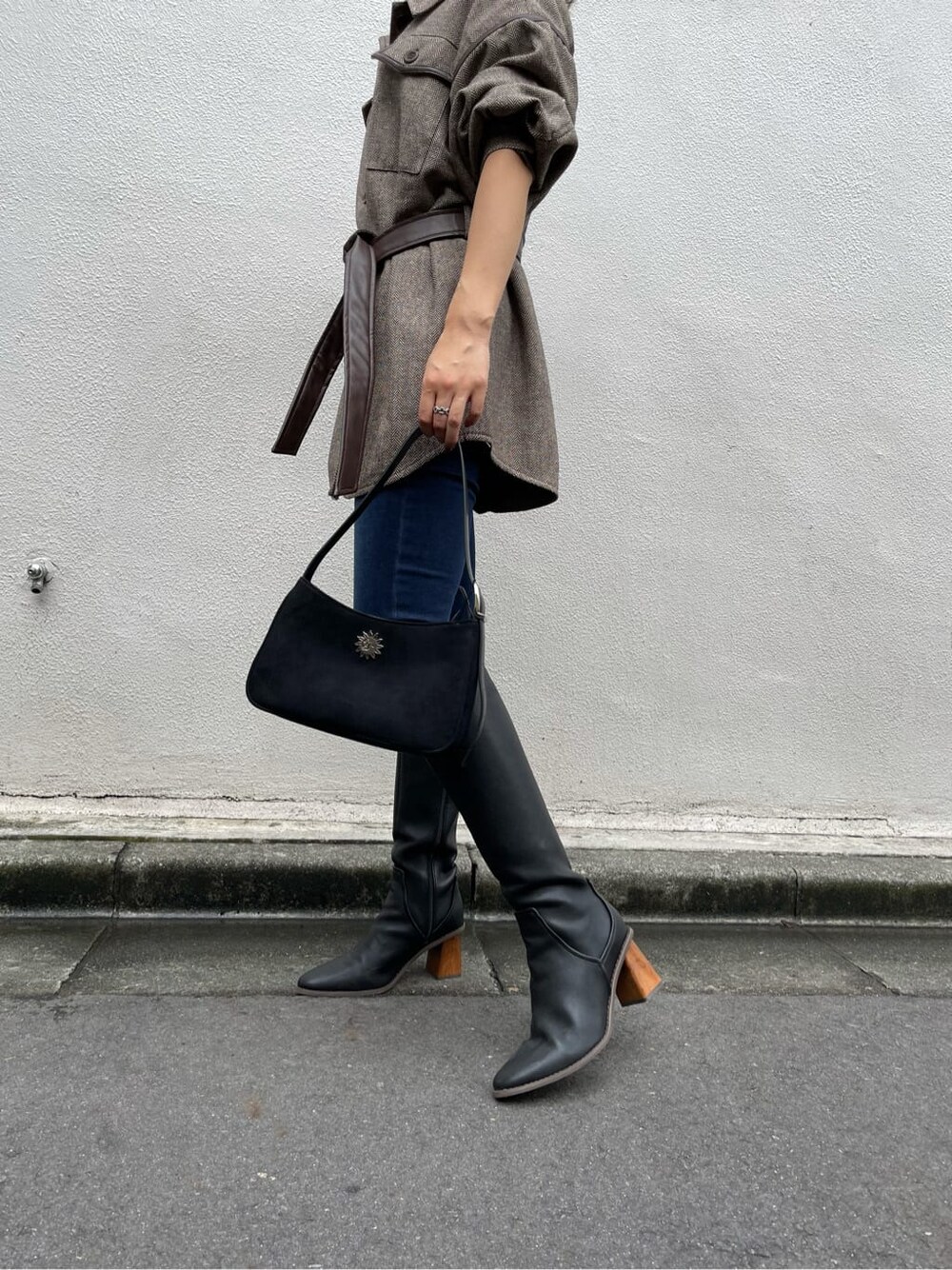 ブラック系のブーツ、ブルー系のデニムパンツ、ブラウン系のその他アウターを着用したレディースの秋コーディネートの6枚目の写真