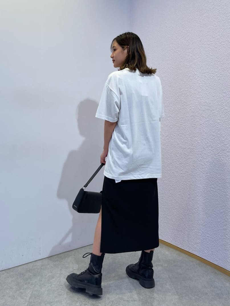 ブラック系のスカート、ブラック系のブーツ、ブラック系のショルダーバッグを着用したレディースの夏コーディネートの2枚目の写真