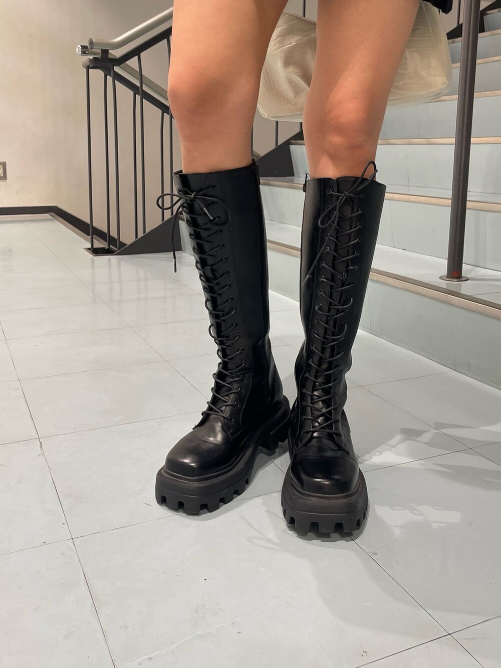 ブルー系のワンピース、ブラック系のブーツ、ブラック系のハンドバッグを着用したレディースの夏コーディネートの9枚目の写真