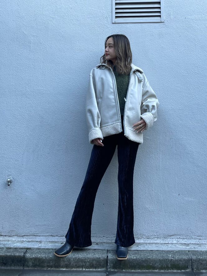 ホワイト系のブルゾン、ベージュ系のニット/セーター、ブラック系のその他パンツを着用したレディースの冬コーディネートの2枚目の写真