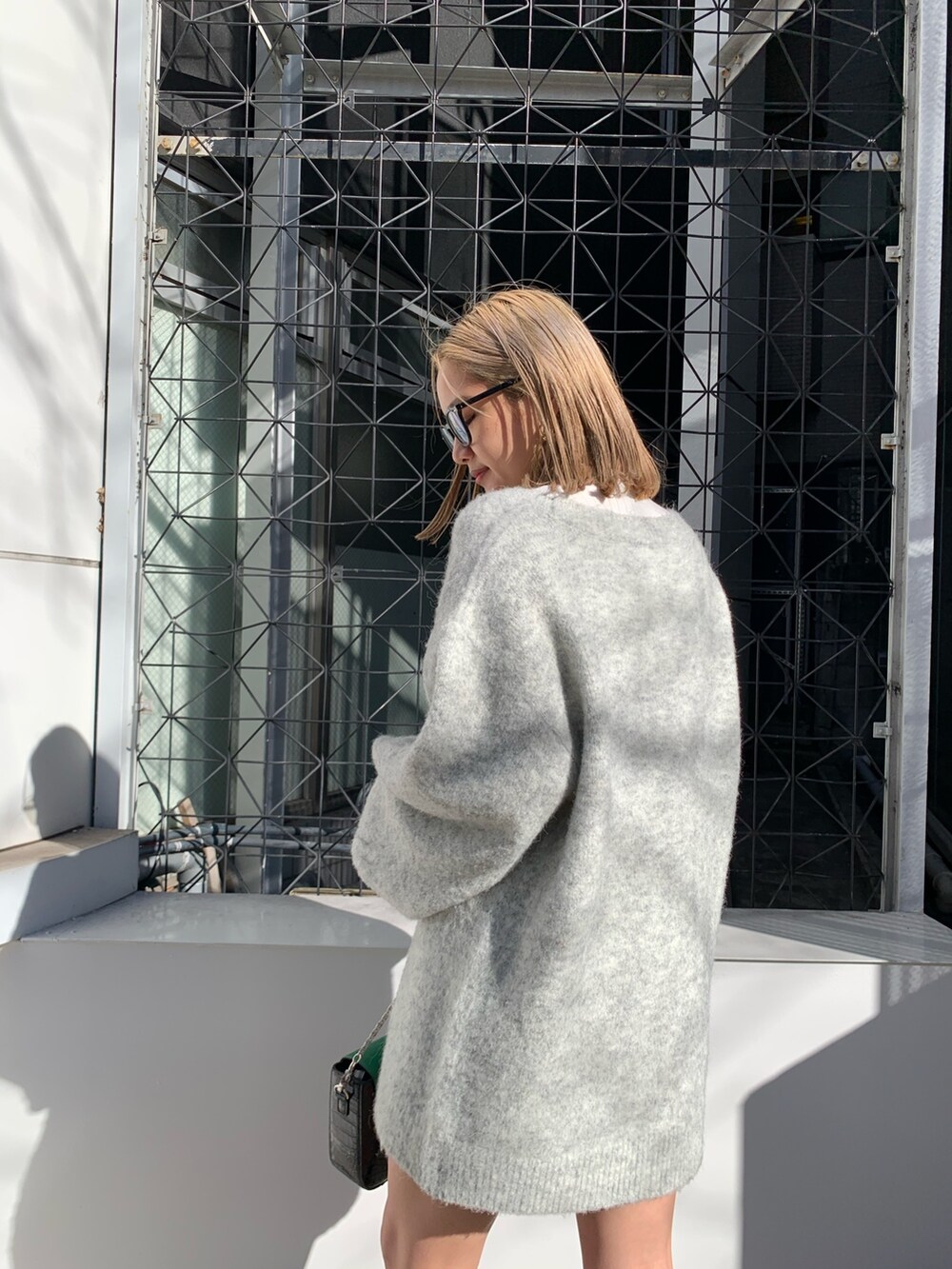 グレー系のカーディガン/ボレロ、ブラック系のブーツ、ホワイト系のTシャツ/カットソーを着用したレディースの冬コーディネートの8枚目の写真