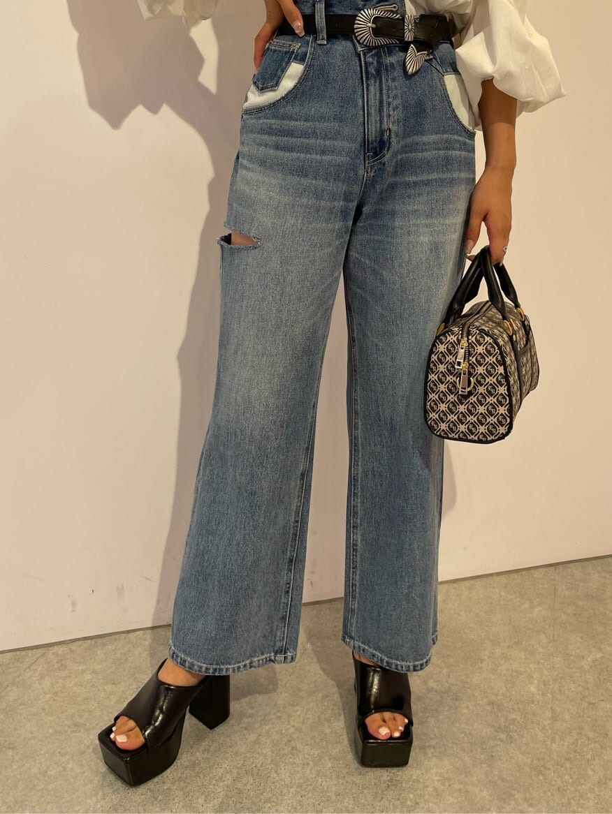 ブラック系のサンダル、ブラック系のボストンバッグ、ブルー系のデニムパンツを着用したレディースの夏コーディネートの5枚目の写真