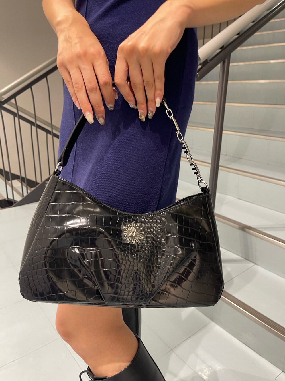 ブルー系のワンピース、ブラック系のブーツ、ブラック系のハンドバッグを着用したレディースの夏コーディネートの8枚目の写真