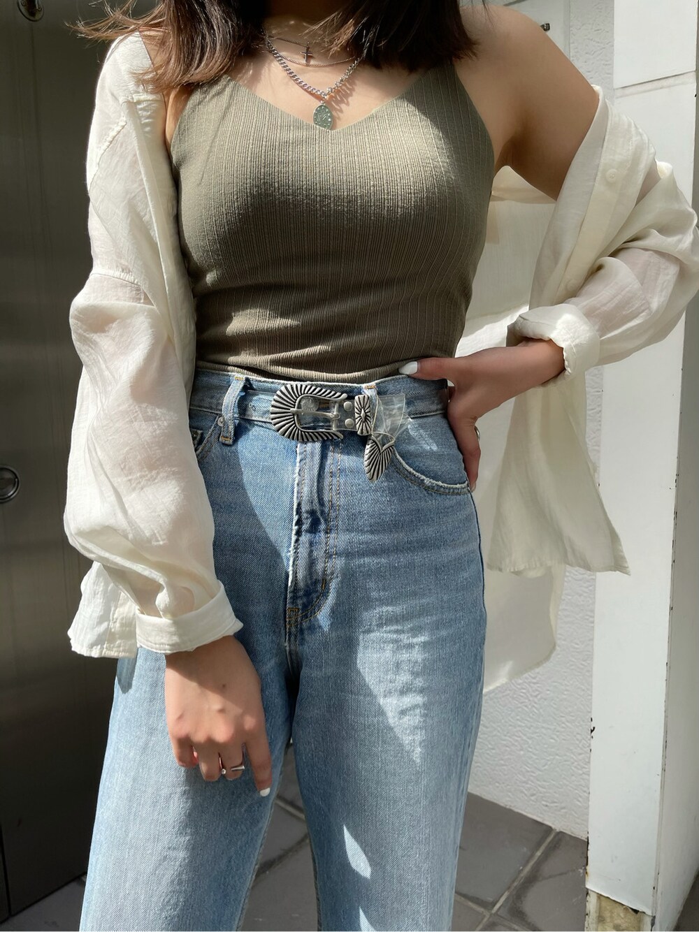 ホワイト系のシャツ/ブラウス、グリーン系のキャミソール、ブルー系のデニムパンツを着用したレディースの春コーディネートの5枚目の写真