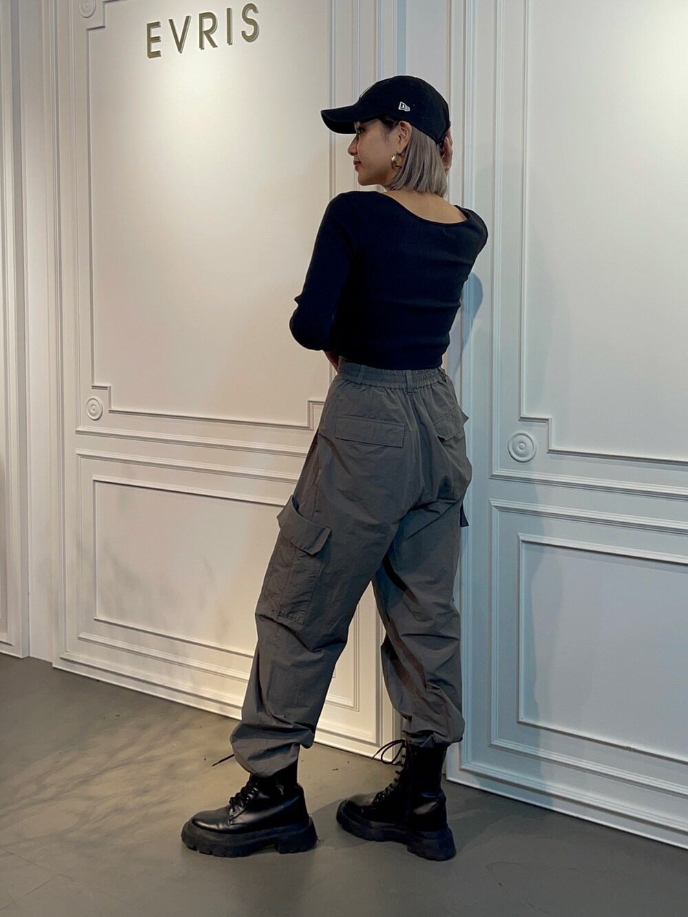 ブラック系のTシャツ/カットソー、グレー系のカーゴパンツ、ブラック系のブーツを着用したレディースの秋コーディネートの2枚目の写真