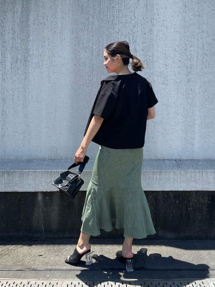 グリーン系のワンピース、ブラック系のサンダル、ブラック系のショルダーバッグを着用したレディースの夏コーディネートの2枚目の写真