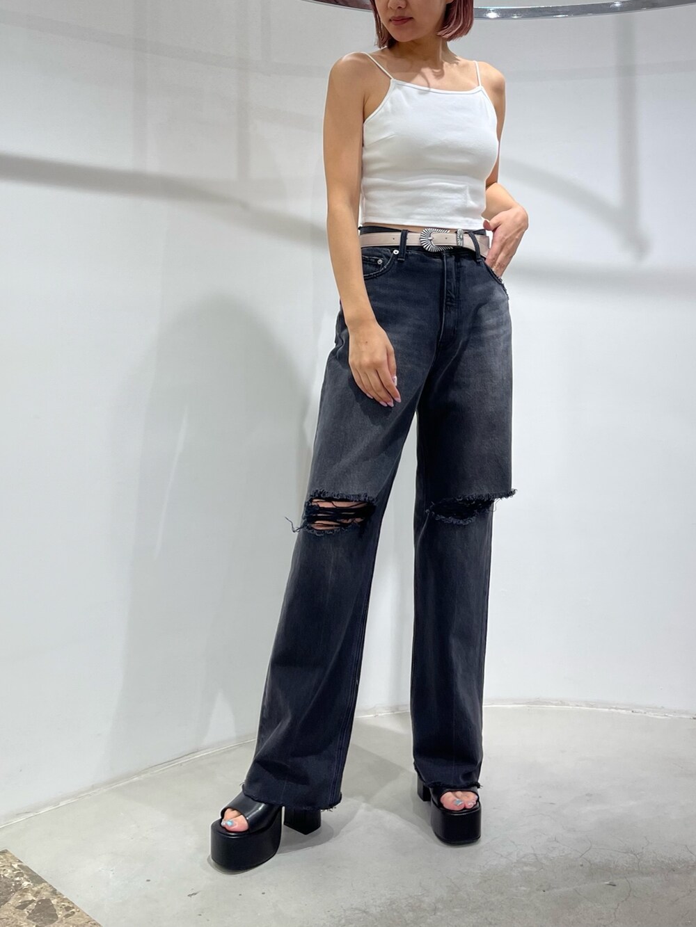 ホワイト系のキャミソール、ブラック系のデニムパンツ、ブラック系のサンダルを着用したレディースの夏コーディネートの5枚目の写真