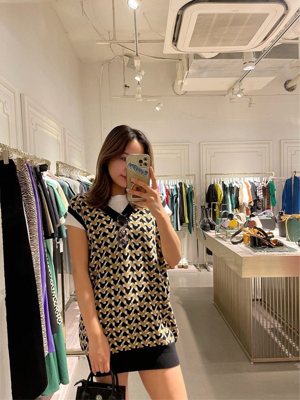 ブラック系のブーツ、ベージュ系のデニムパンツ、ブラック系のニット/セーターを着用したレディースの春コーディネートの2枚目の写真