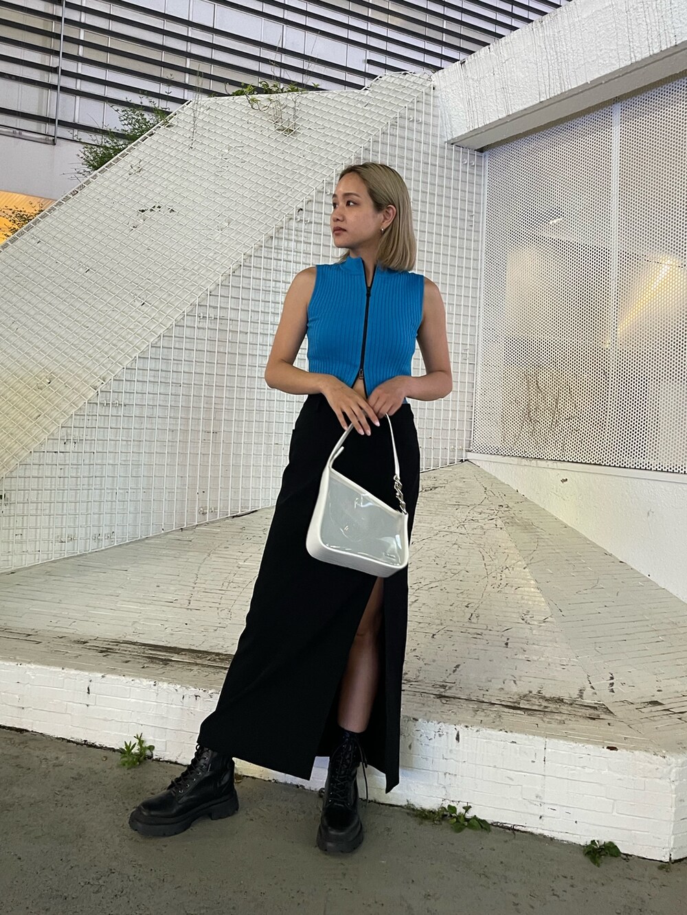 ブラック系のブーツ、ホワイト系のハンドバッグ、ブルー系のタンクトップを着用したレディースの夏コーディネートの2枚目の写真