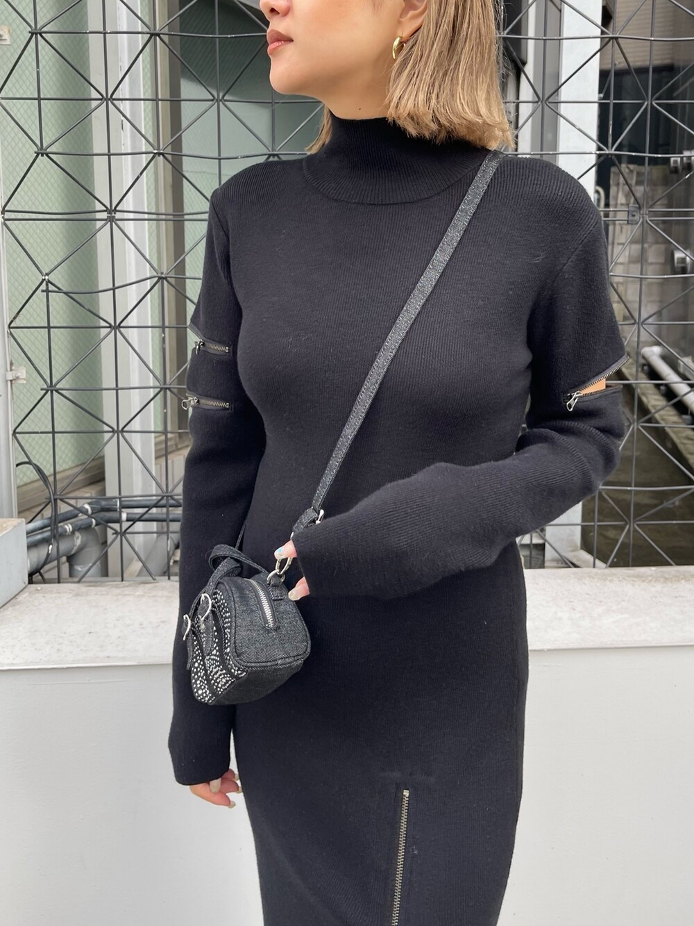 ブラック系のワンピース、ブラック系のハンドバッグ、ブラック系のブーツを着用したレディースの秋コーディネートの6枚目の写真