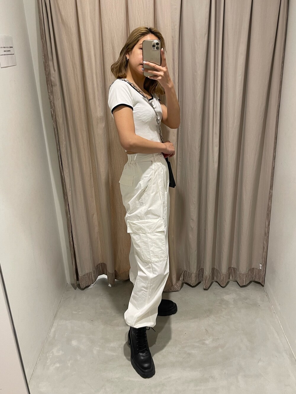 ホワイト系のカーゴパンツ、ブラック系のブーツ、ホワイト系のTシャツ/カットソーを着用したレディースの春コーディネートの3枚目の写真