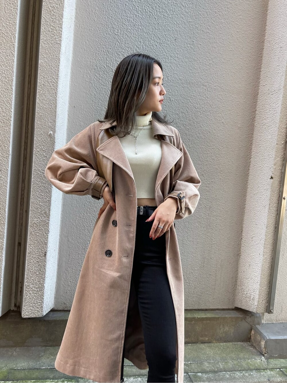 ブラック系のデニムパンツ、ベージュ系のトレンチコート、ホワイト系のニット/セーターを着用したレディースの秋コーディネートの4枚目の写真