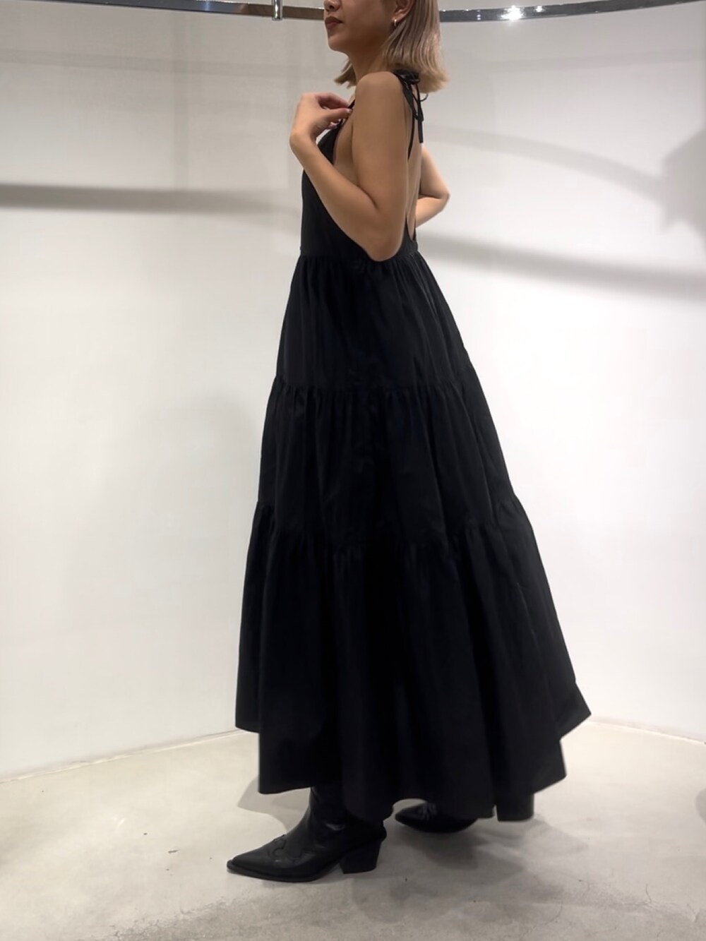 ブラック系のワンピース、ブラック系のブーツを着用したレディースの夏コーディネートの6枚目の写真