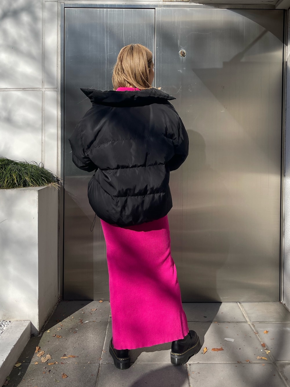 ブラック系のワンピース、ブラック系のショルダーバッグ、ブラック系のダウンジャケット/コートを着用したレディースの冬コーディネートの4枚目の写真