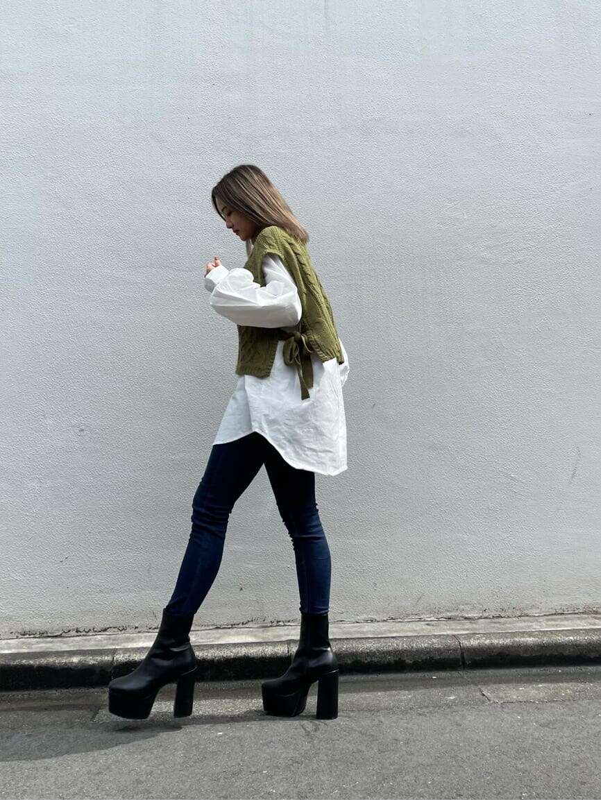 ブルー系のデニムパンツ、ブラック系のブーツ、ホワイト系のシャツ/ブラウスを着用したレディースの秋コーディネートの3枚目の写真