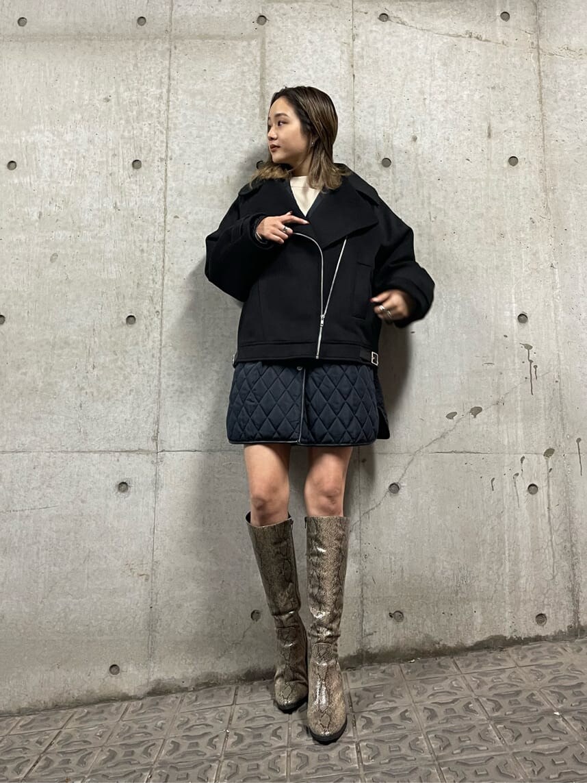 ブラック系のブルゾン、ホワイト系のニット/セーター、ブラック系のスカートを着用したレディースの秋コーディネートの3枚目の写真