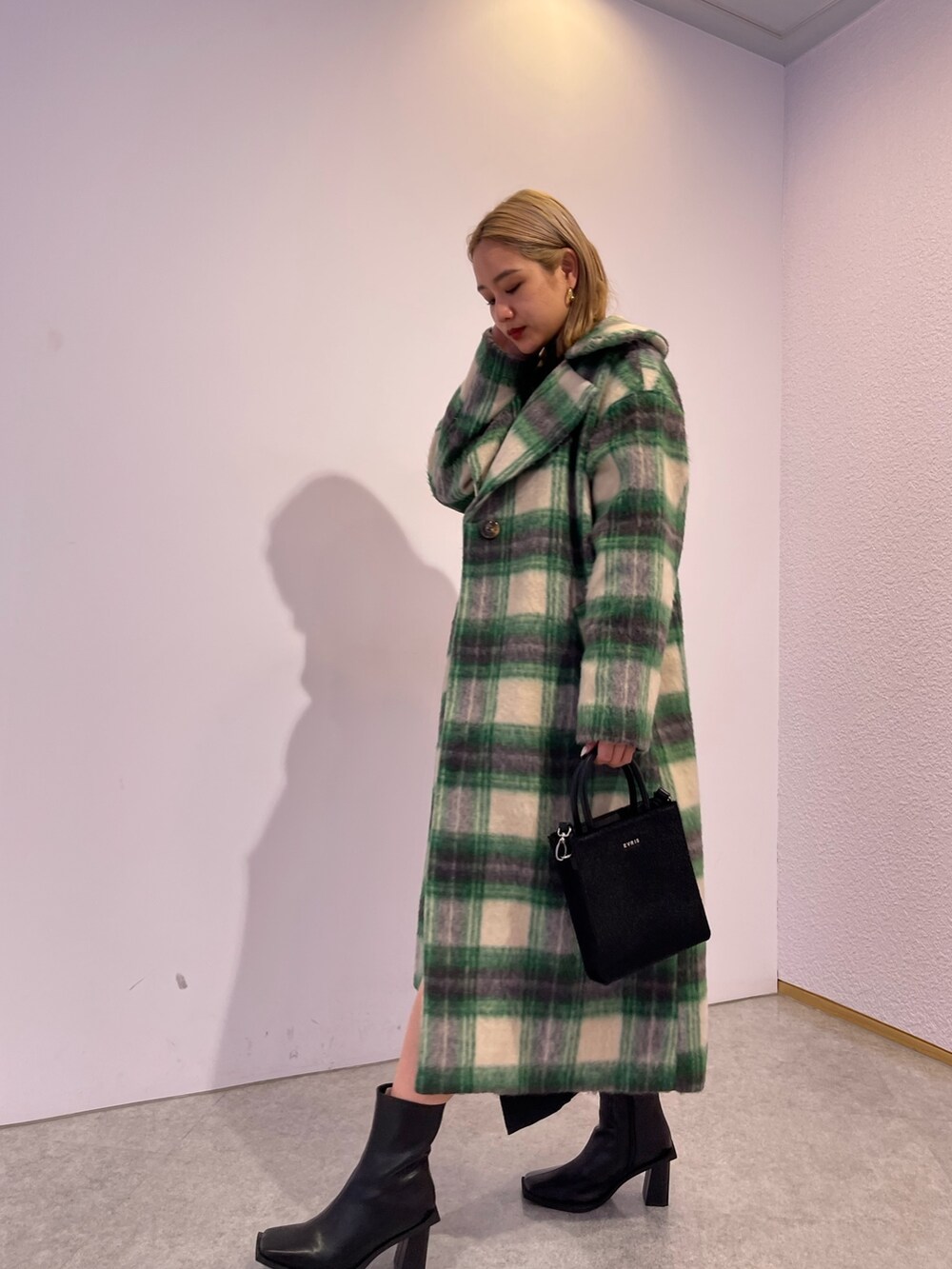 グリーン系のその他アウター、ブラック系のブーツ、ブラック系のワンピースを着用したレディースの冬コーディネートの3枚目の写真