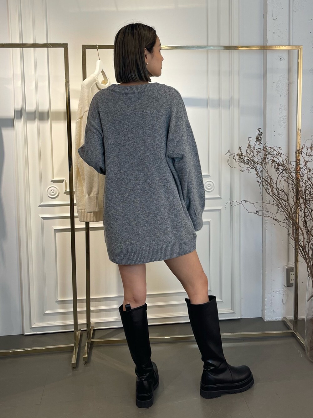 グレー系のニット/セーター、ブラック系のブーツを着用したレディースの秋コーディネートの4枚目の写真