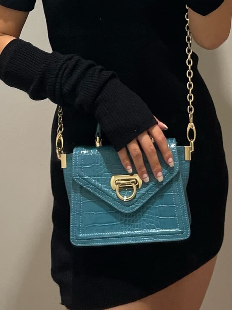 ブラック系のブーツ、ブラック系のワンピース、グリーン系のショルダーバッグを着用したレディースの秋コーディネートの7枚目の写真