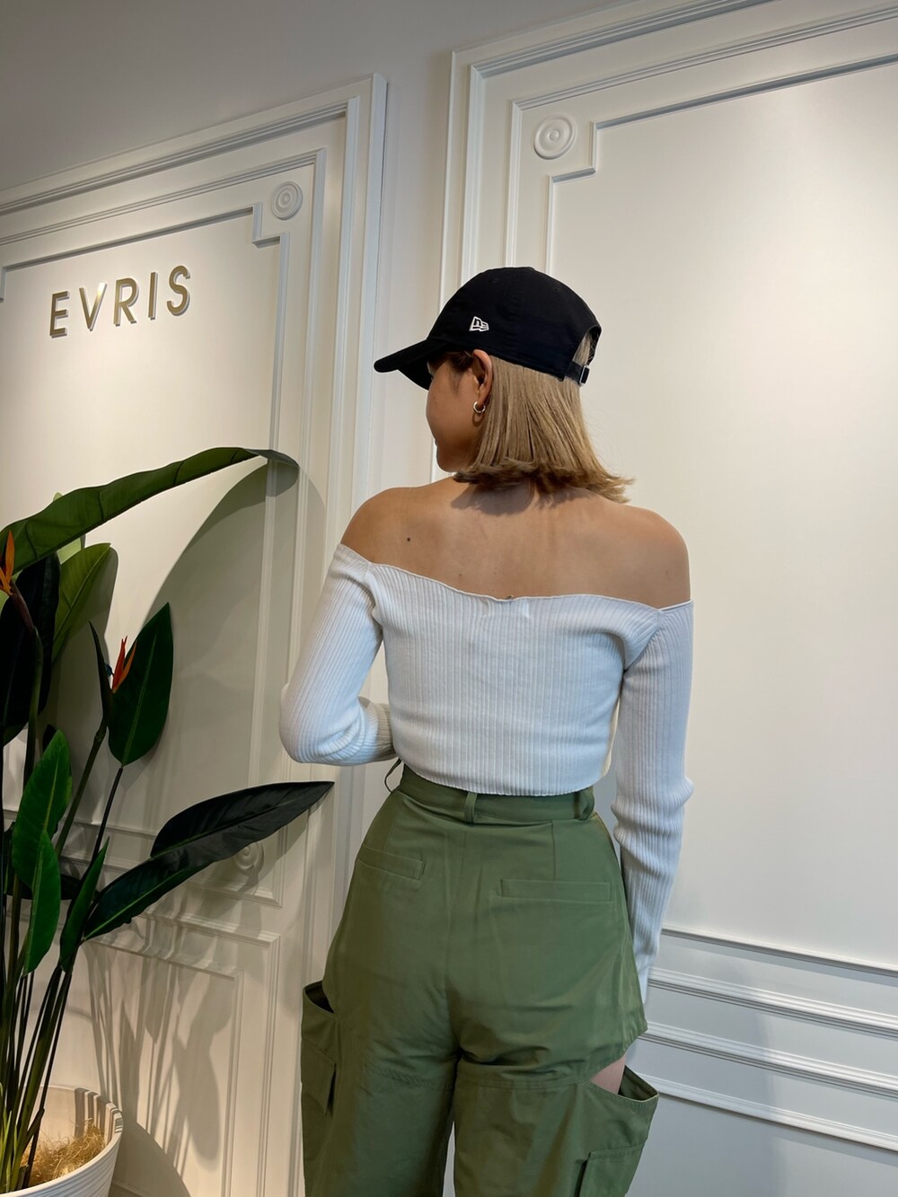 グリーン系のニット/セーター、ブラック系のブーツ、ベージュ系のカーゴパンツを着用したレディースの春コーディネートの5枚目の写真