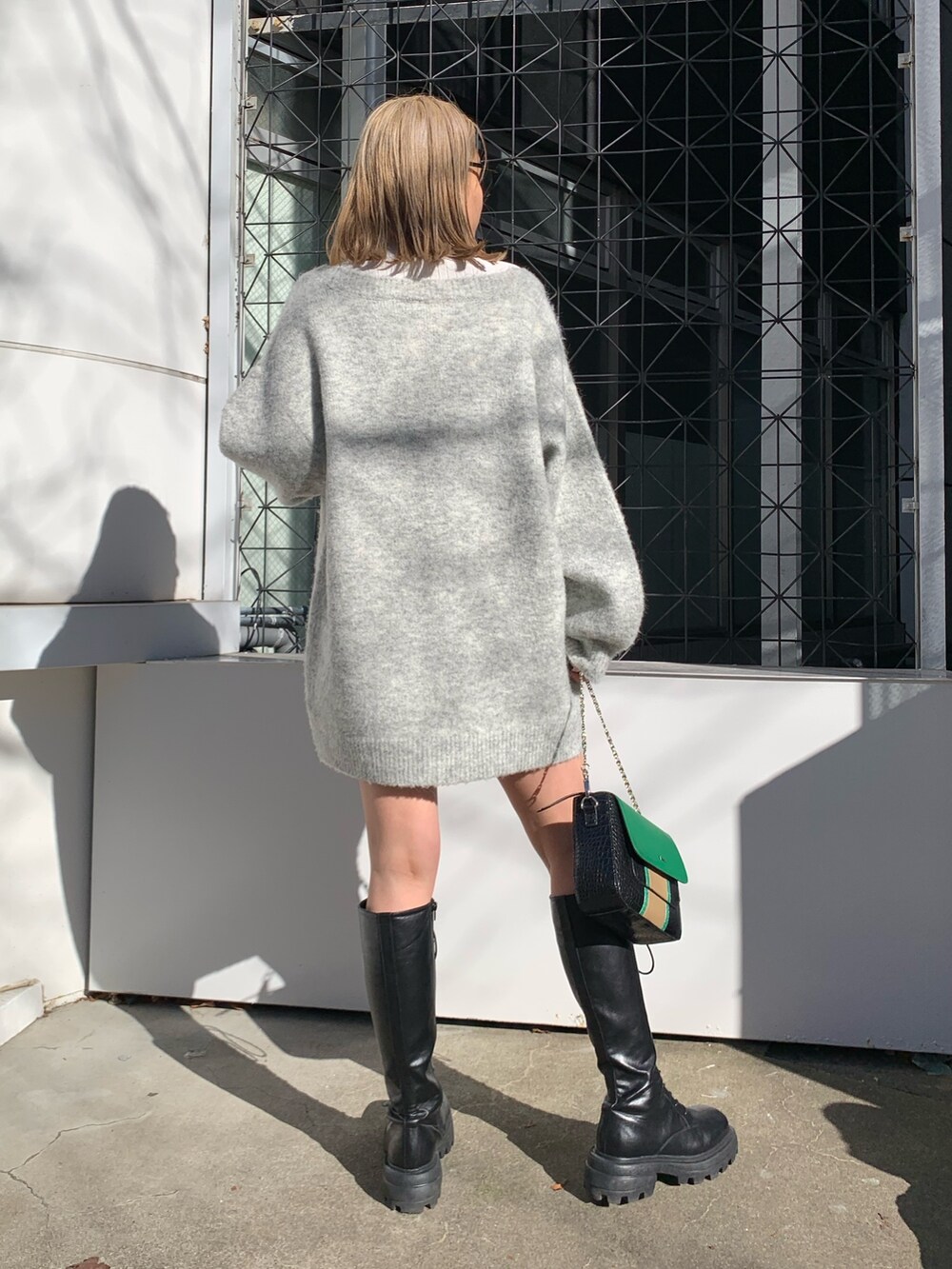 グレー系のカーディガン/ボレロ、ブラック系のブーツ、ホワイト系のTシャツ/カットソーを着用したレディースの冬コーディネートの4枚目の写真