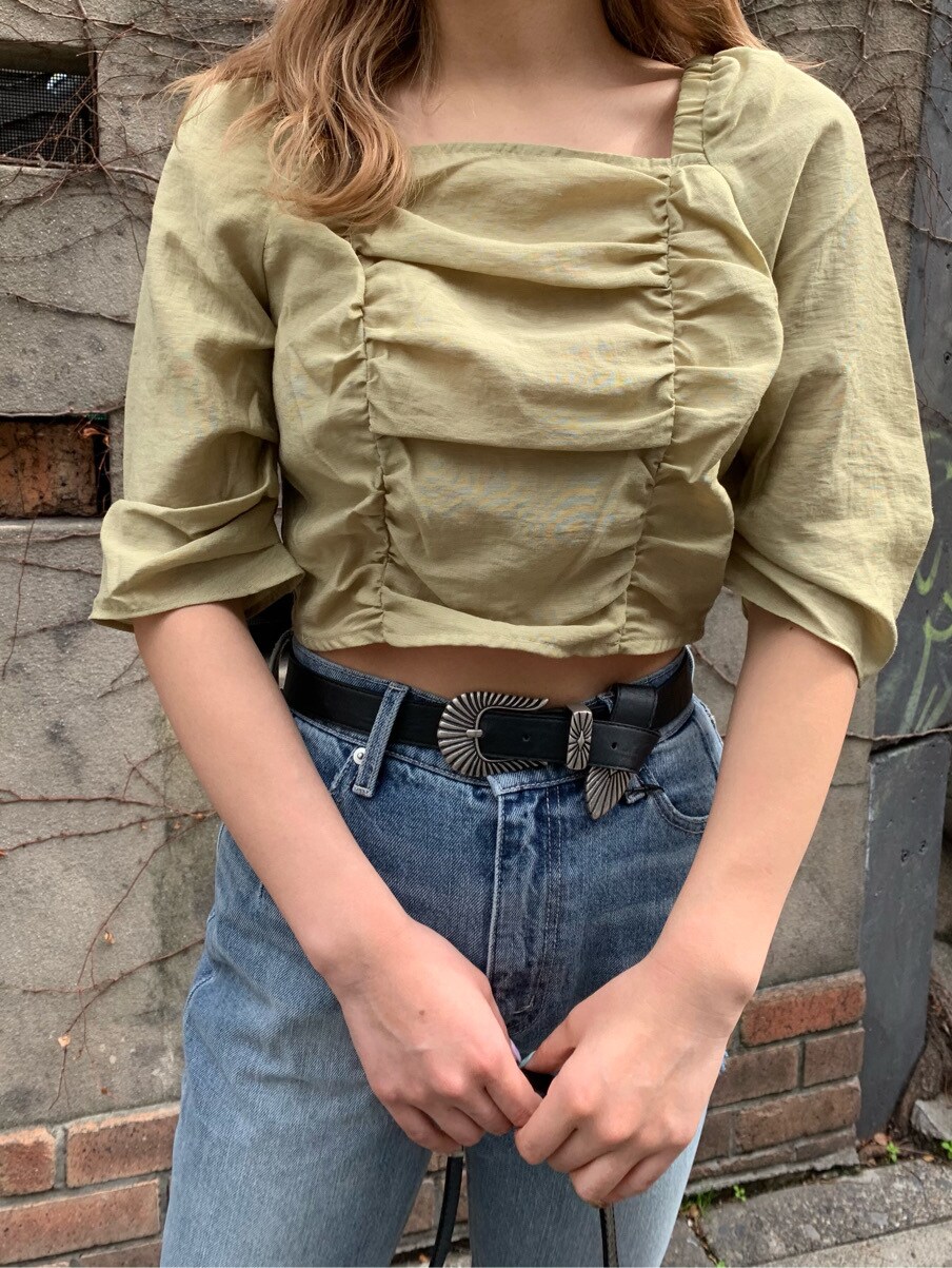 ブルー系のデニムパンツ、グリーン系のシャツ/ブラウス、ブラック系のショルダーバッグを着用したレディースの春コーディネートの7枚目の写真