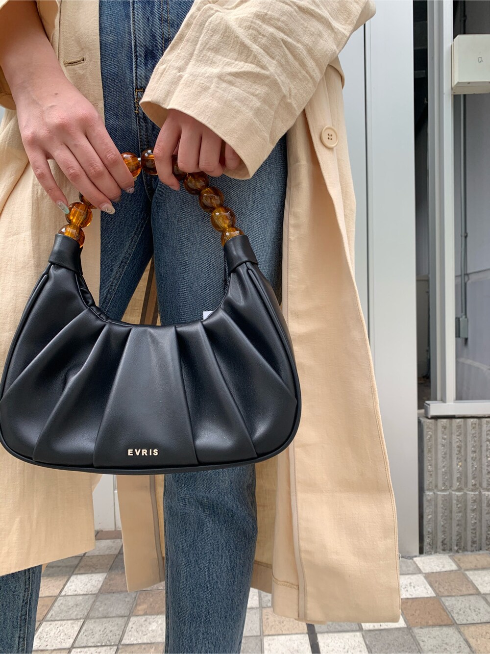 ブルー系のデニムパンツ、ブラック系のサンダル、ベージュ系のチェスターコートを着用したレディースの春コーディネートの7枚目の写真