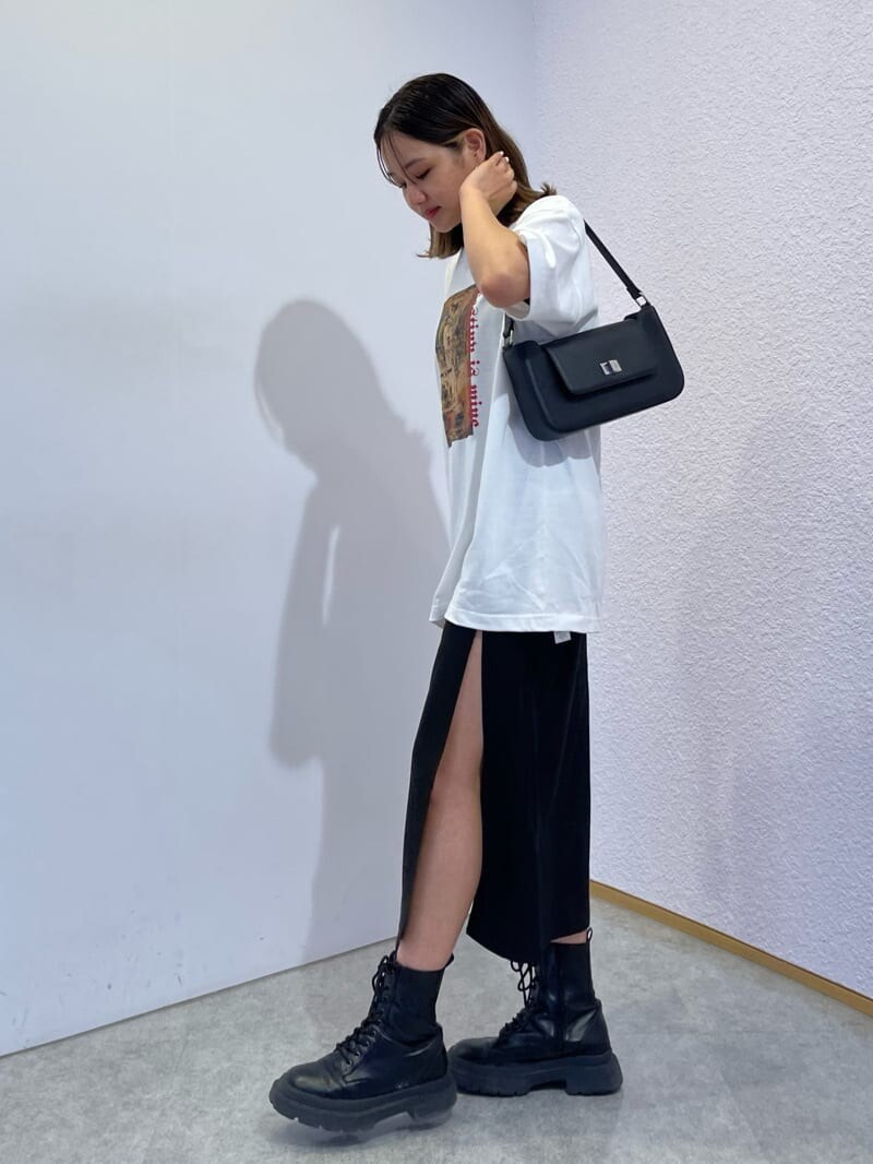 ブラック系のスカート、ブラック系のブーツ、ブラック系のショルダーバッグを着用したレディースの夏コーディネートの3枚目の写真