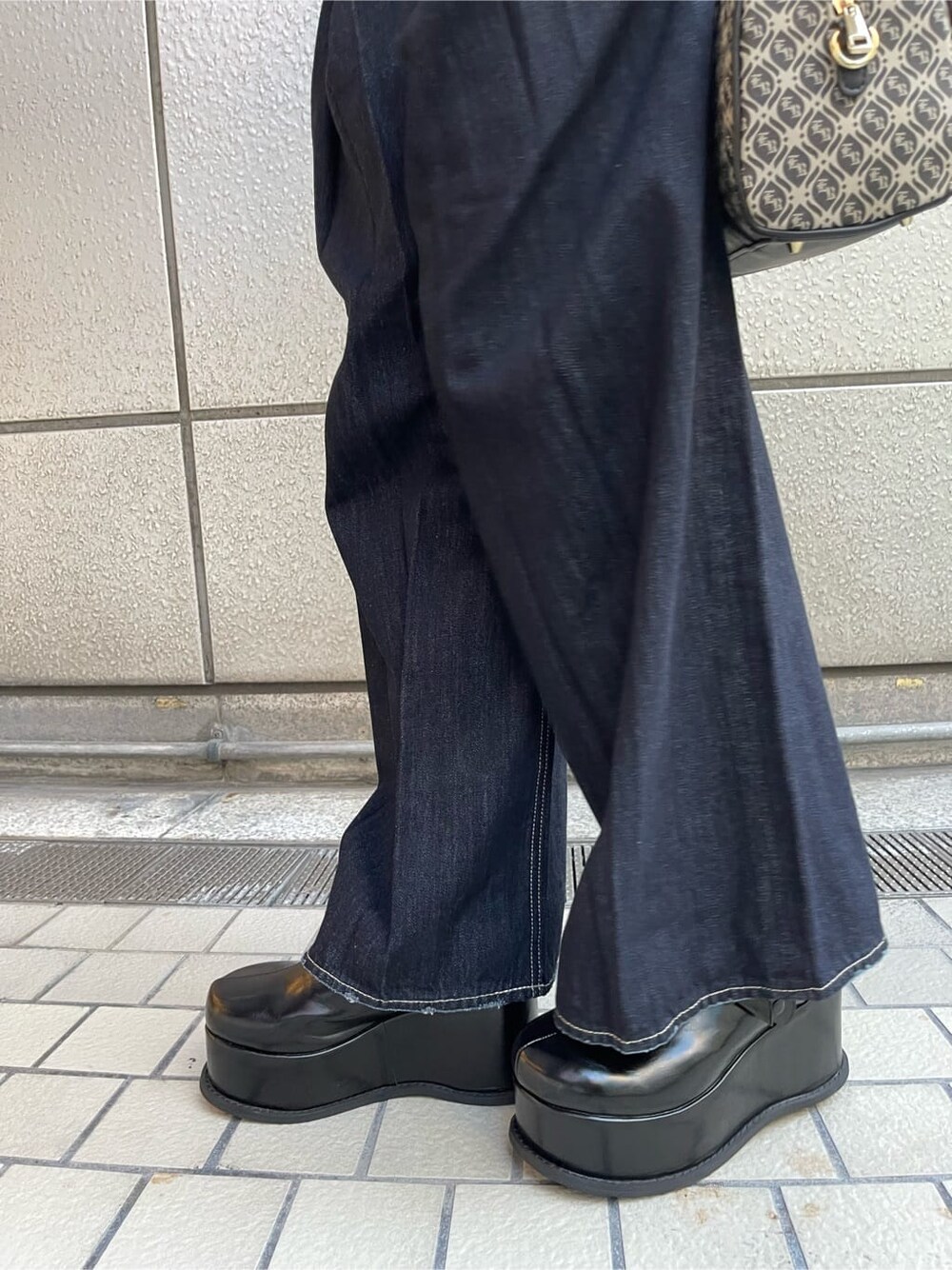 ブラック系のスリッポン、ブラック系のボストンバッグ、ブルー系のデニムパンツを着用したレディースの夏コーディネートの10枚目の写真