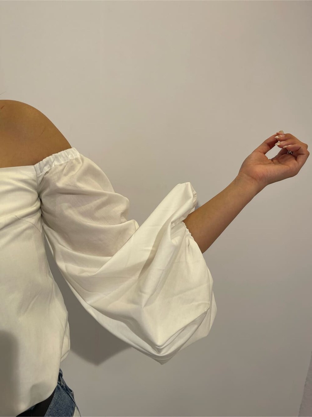 ブラック系のサンダル、ブラック系のボストンバッグ、ブルー系のデニムパンツを着用したレディースの夏コーディネートの8枚目の写真