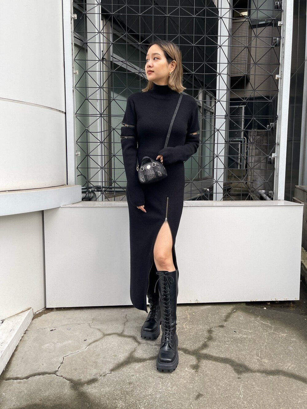 ブラック系のワンピース、ブラック系のハンドバッグ、ブラック系のブーツを着用したレディースの秋コーディネートの3枚目の写真