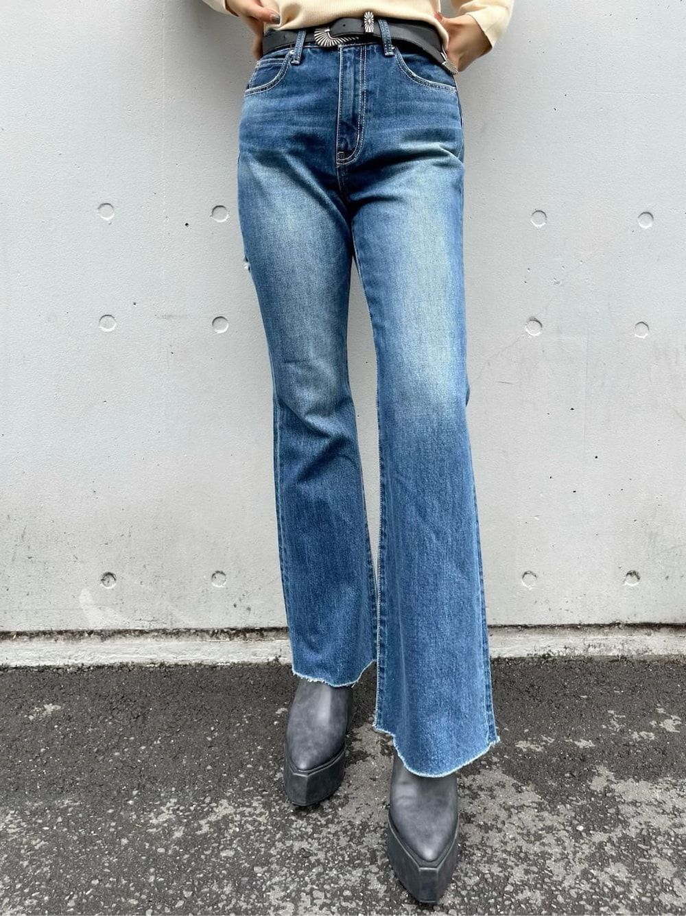 ブラック系のサンダル、ブルー系のデニムパンツ、ホワイト系のベルトを着用したレディースの秋コーディネートの7枚目の写真