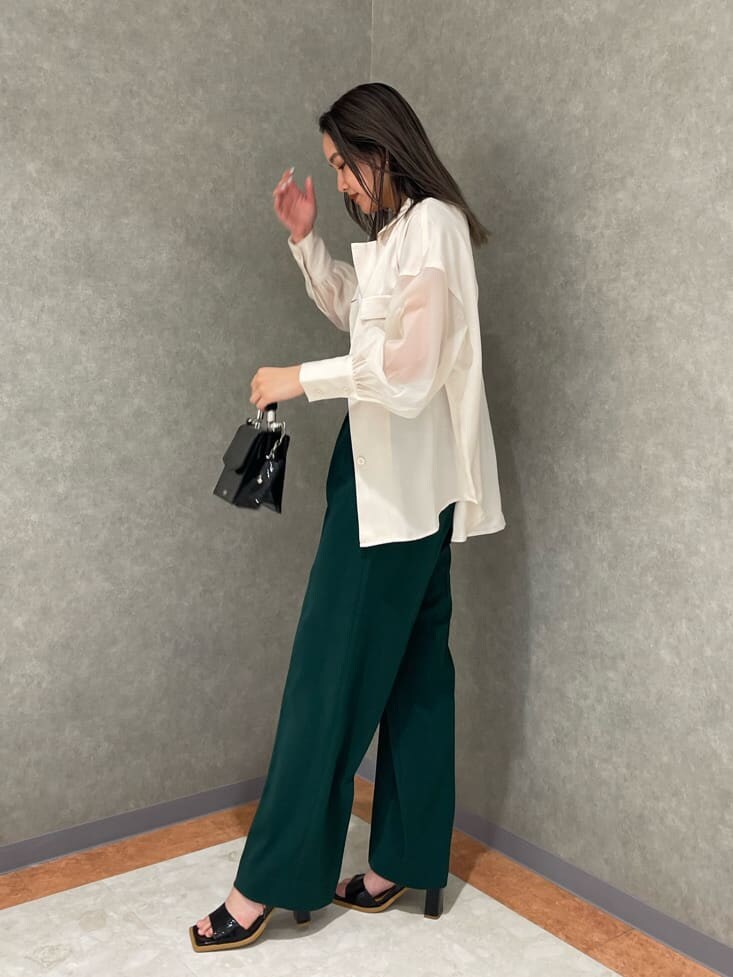ホワイト系のタンクトップ、グリーン系のスラックス、ホワイト系のシャツ/ブラウスを着用したレディースの春コーディネートの2枚目の写真