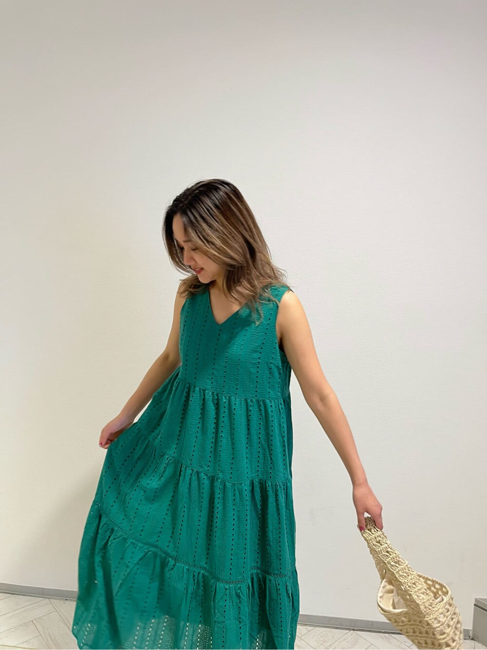 ブラック系のブーツ、グリーン系のワンピース、ベージュ系のショルダーバッグを着用したレディースの春コーディネートの8枚目の写真