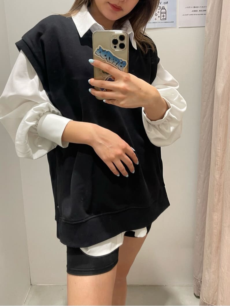 ホワイト系のシャツ/ブラウス、ブラック系のブーツ、ブラック系のベストを着用したレディースの春コーディネートの3枚目の写真