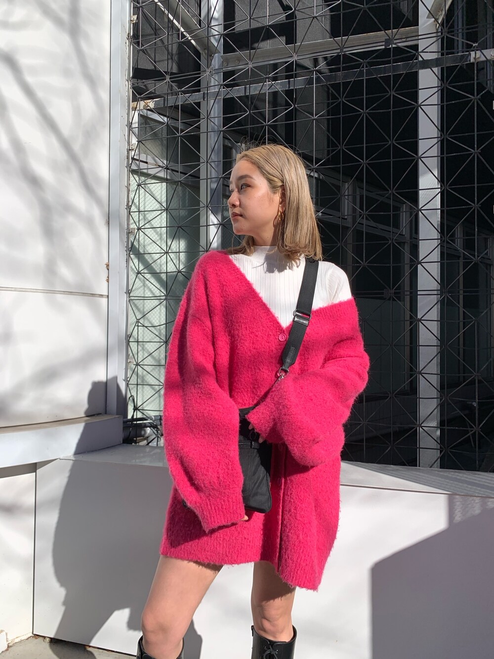 ピンク系のカーディガン/ボレロ、ホワイト系のTシャツ/カットソー、ブラック系のブーツを着用したレディースの冬コーディネートの4枚目の写真