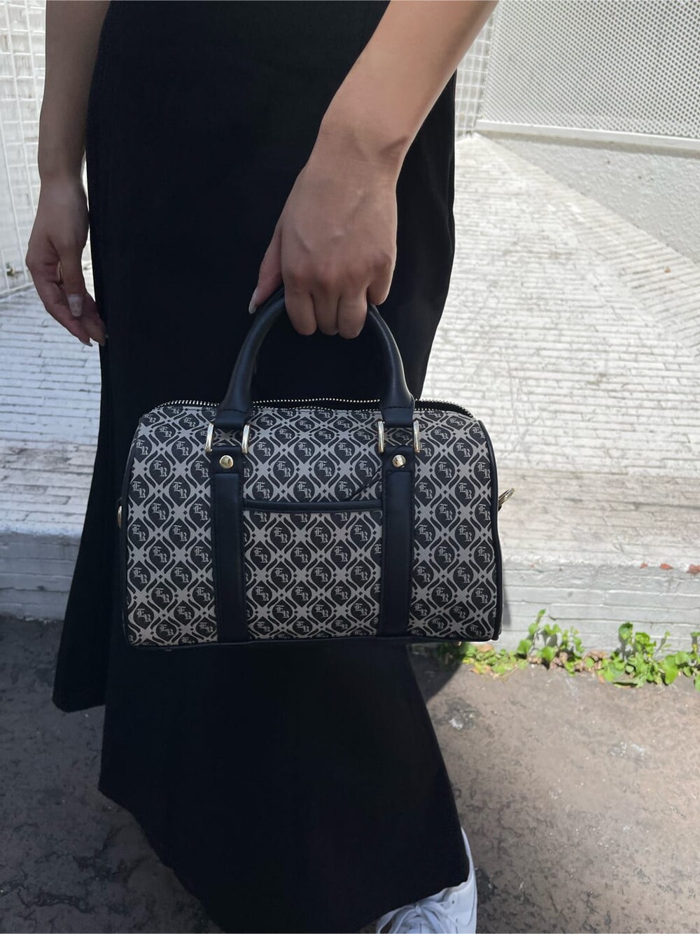 ブラック系のスカート、ブラック系のボストンバッグ、ホワイト系のTシャツ/カットソーを着用したレディースの夏コーディネートの7枚目の写真