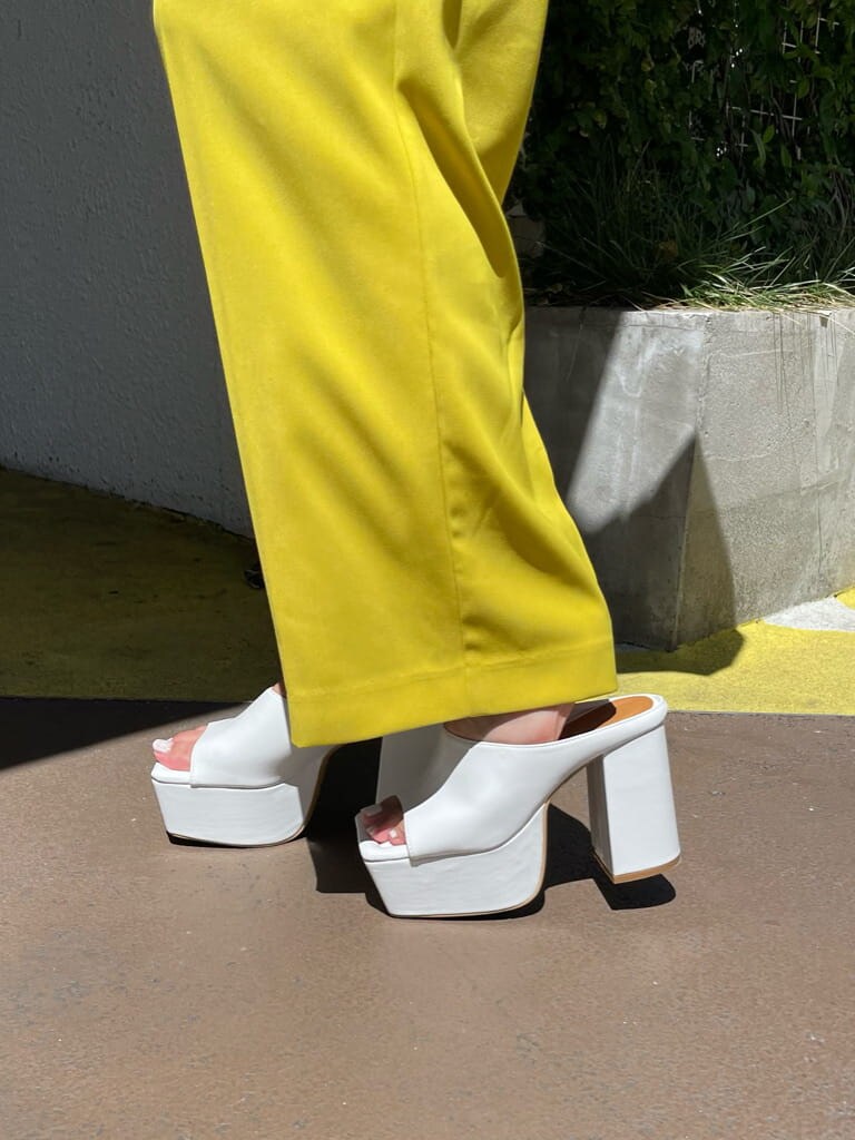 ホワイト系のサンダル、ホワイト系のシャツ/ブラウス、イエロー系のスラックスを着用したレディースの夏コーディネートの6枚目の写真