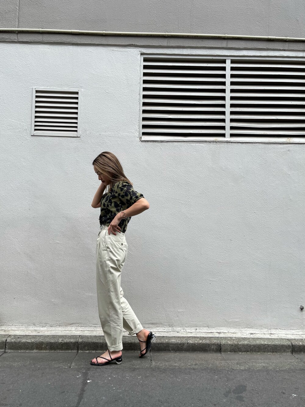 ブラック系のサンダル、ホワイト系のその他パンツ、ベージュ系のシャツ/ブラウスを着用したレディースの春コーディネートの2枚目の写真