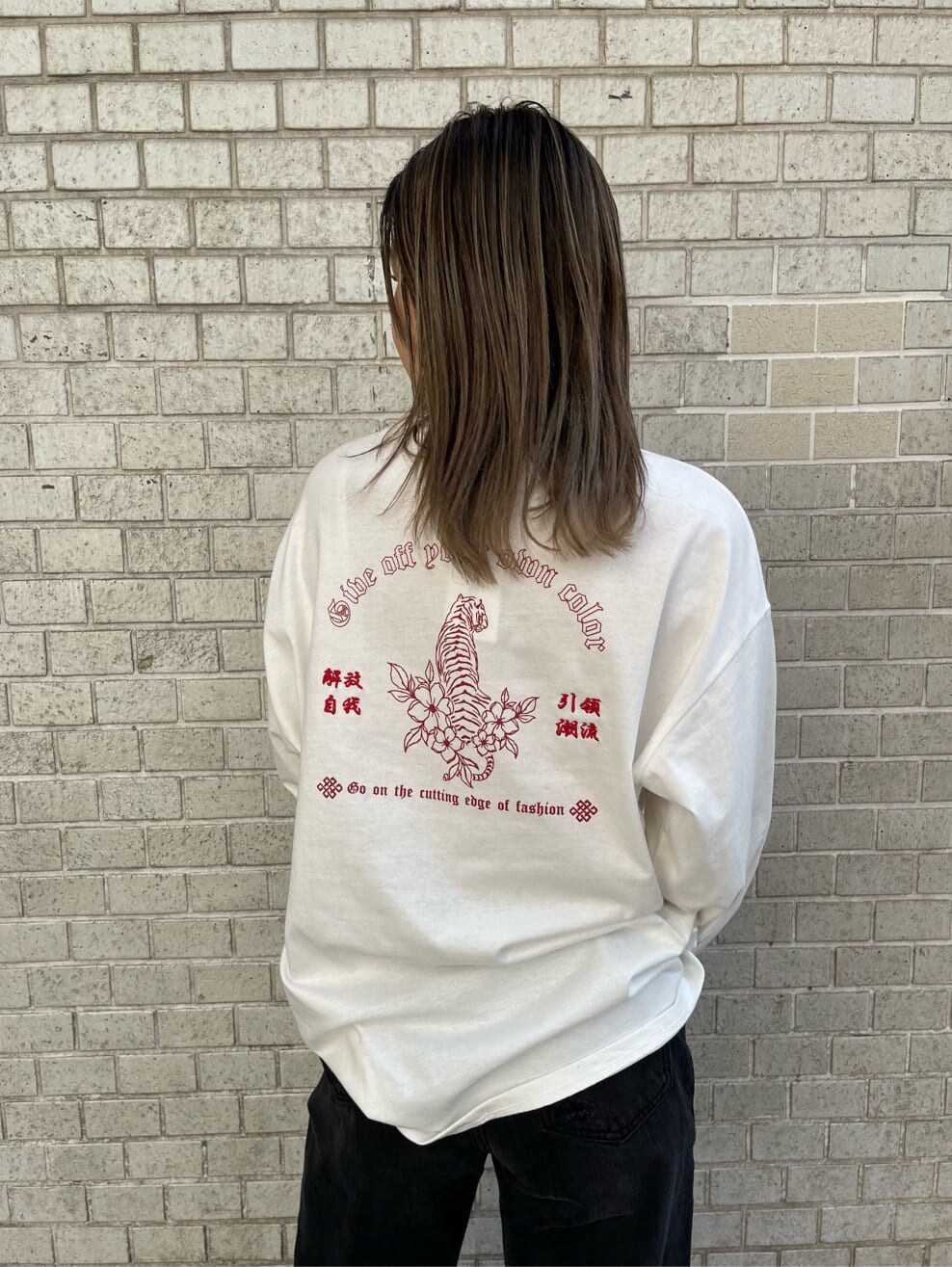 ブラック系のデニムパンツ、ホワイト系のTシャツ/カットソー、ホワイト系のベルトを着用したレディースの冬コーディネートの5枚目の写真